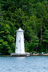 Herrick Cove Light Tower by Evergreen Trees of Lake Sunapee